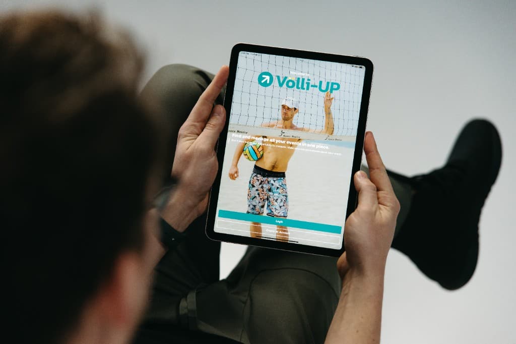 Someone holding a tablet showing the Völli-UP app